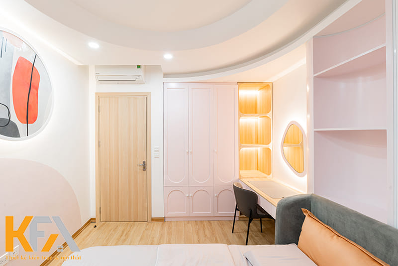 Chiếc tủ đa năng âm tường màu hồng được đặt vừa vặn, gọn gàng cạnh cửa ra vào